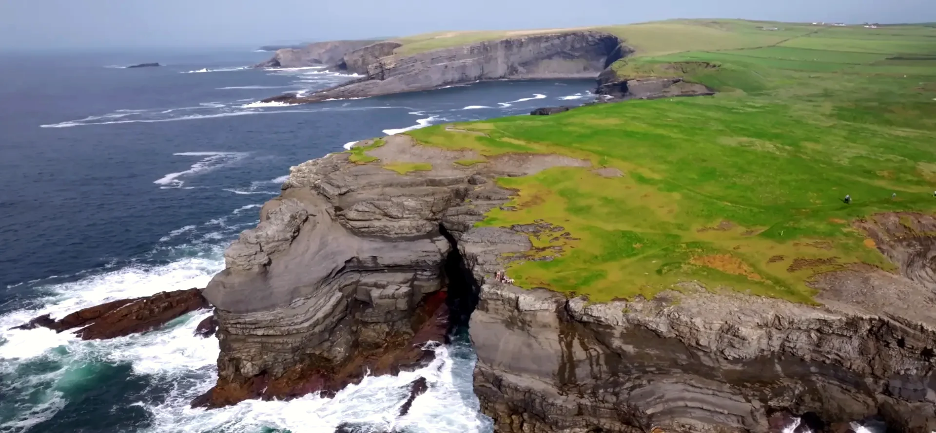 Green cliff-top trail and rocky headland along the Kilkee coastline