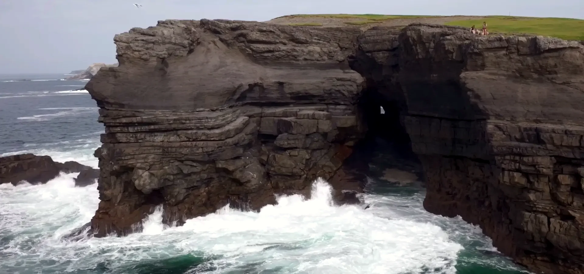 Genuine aerial view of a Kilkee rock chasm and Atlantic surf