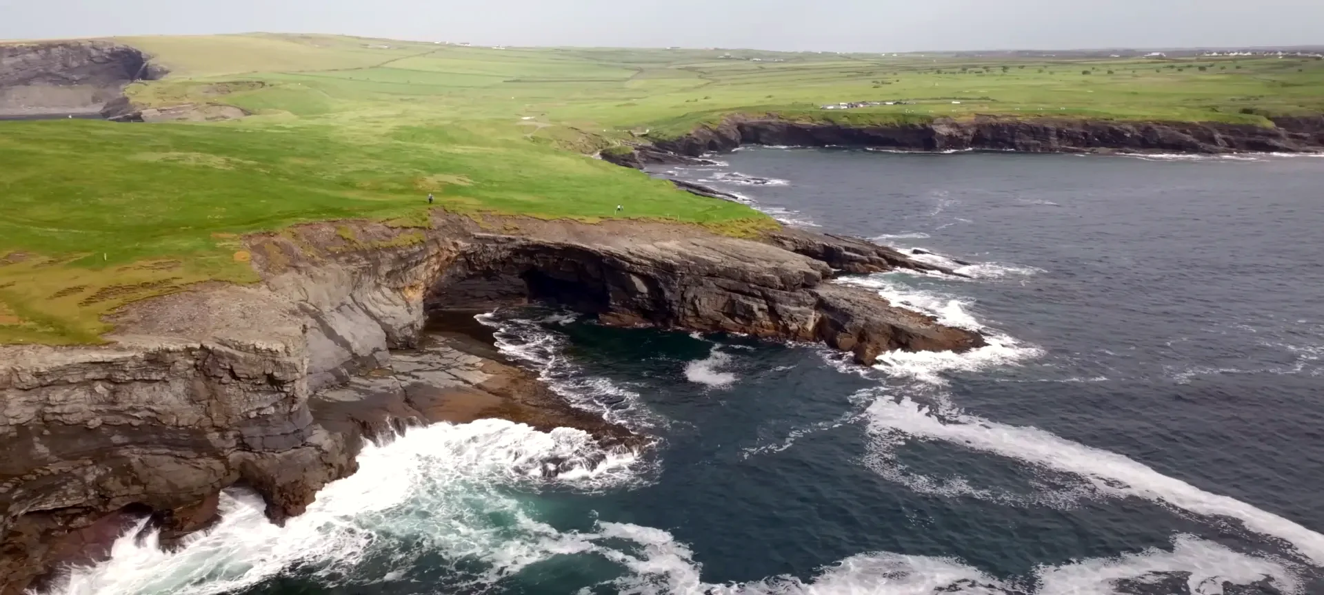 Aerial photograph of grassy Kilkee cliffs and the Atlantic rock amphitheatre
